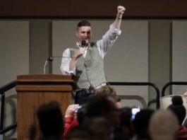 Richard Spencer gives white power salute during a talk at Texas A&M University, Dec 2016 (source: AP via ABC news, https://abcnews.go.com/US/hundreds-protest-white-nationalist-texas-university/story?id=44029112)